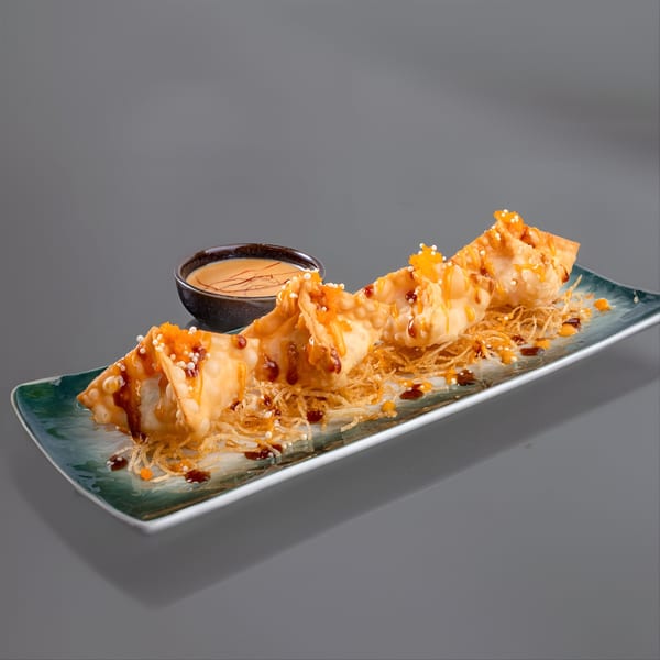 YuGo Sushi & More's fried wontons drizzled with sauce, served on a green plate with a dipping bowl.